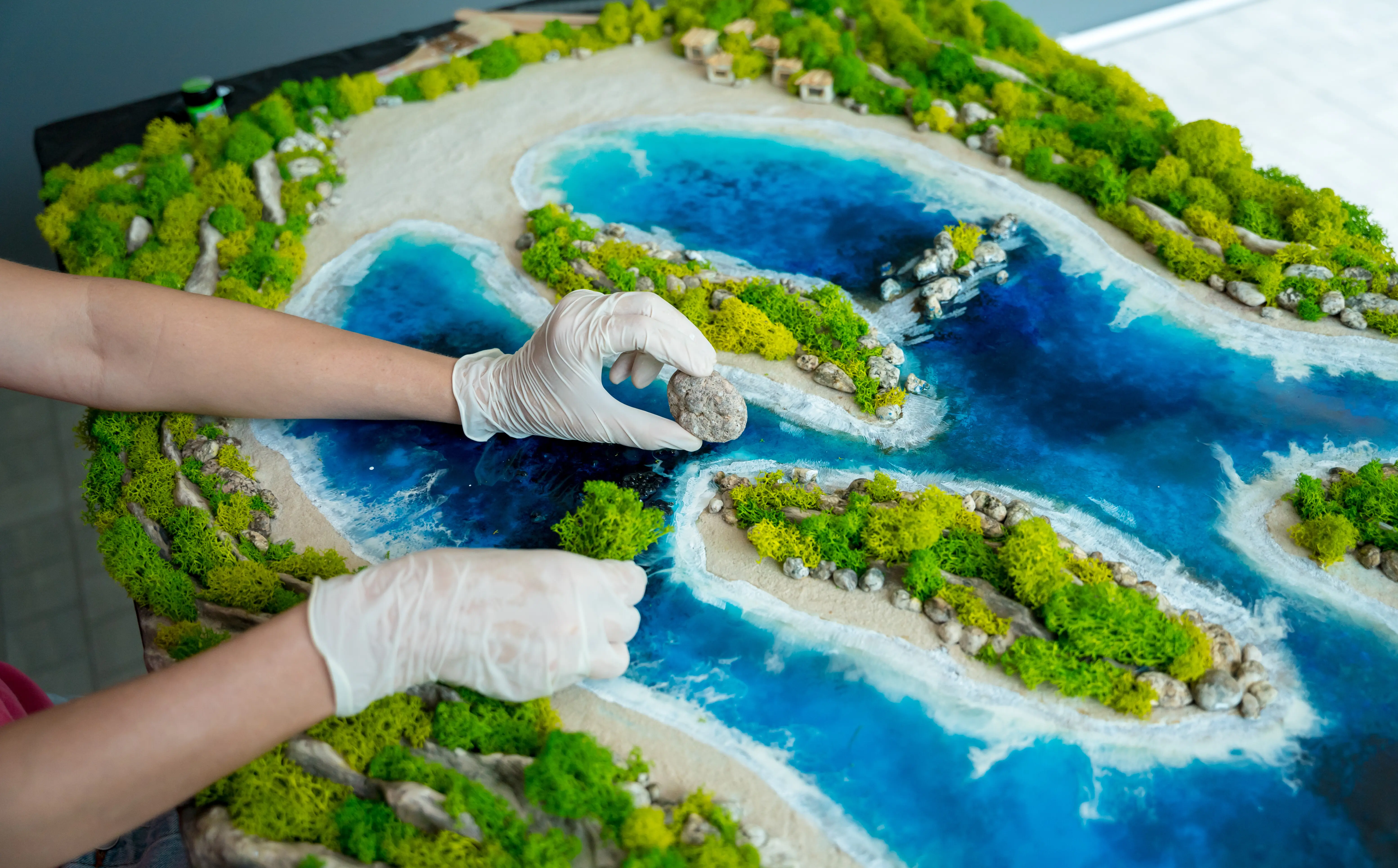 Der Herstellungsprozess der Kunstdekoration aus Epoxidharz, Natursteinen und Moos.